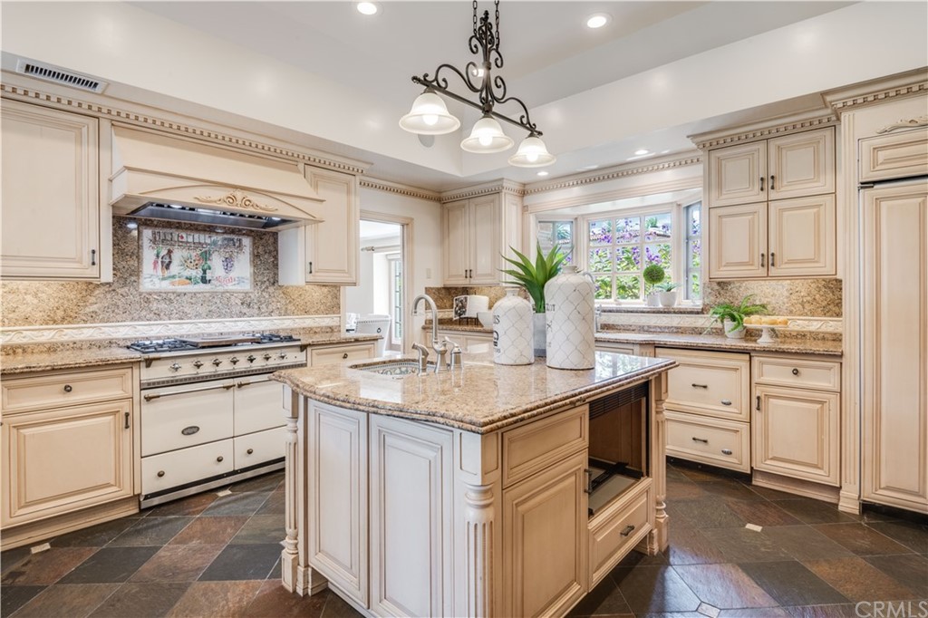 4255 Chestnut Avenue Long Beach, CA 90807 - Photo 12 of 48 a kitchen with white cabinets and chandelier