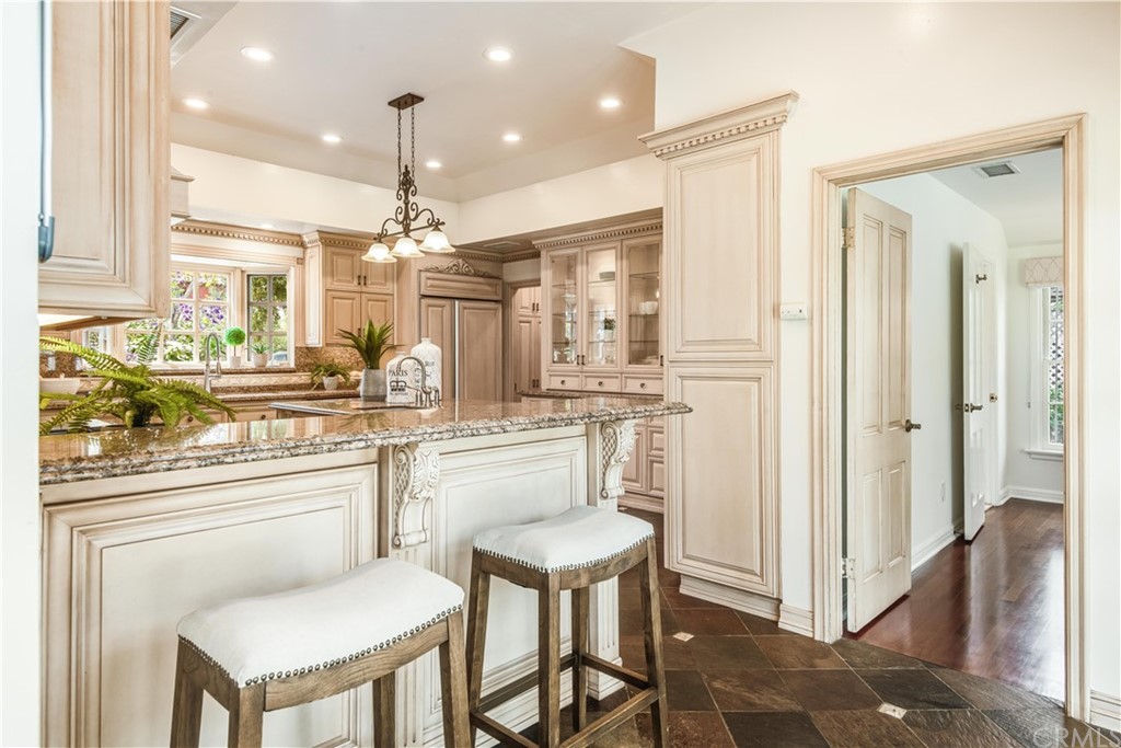 4255 Chestnut Avenue Long Beach, CA 90807 - Photo 10 of 48 a kitchen with stainless steel appliances kitchen island granite countertop a table chairs and a refrigerator