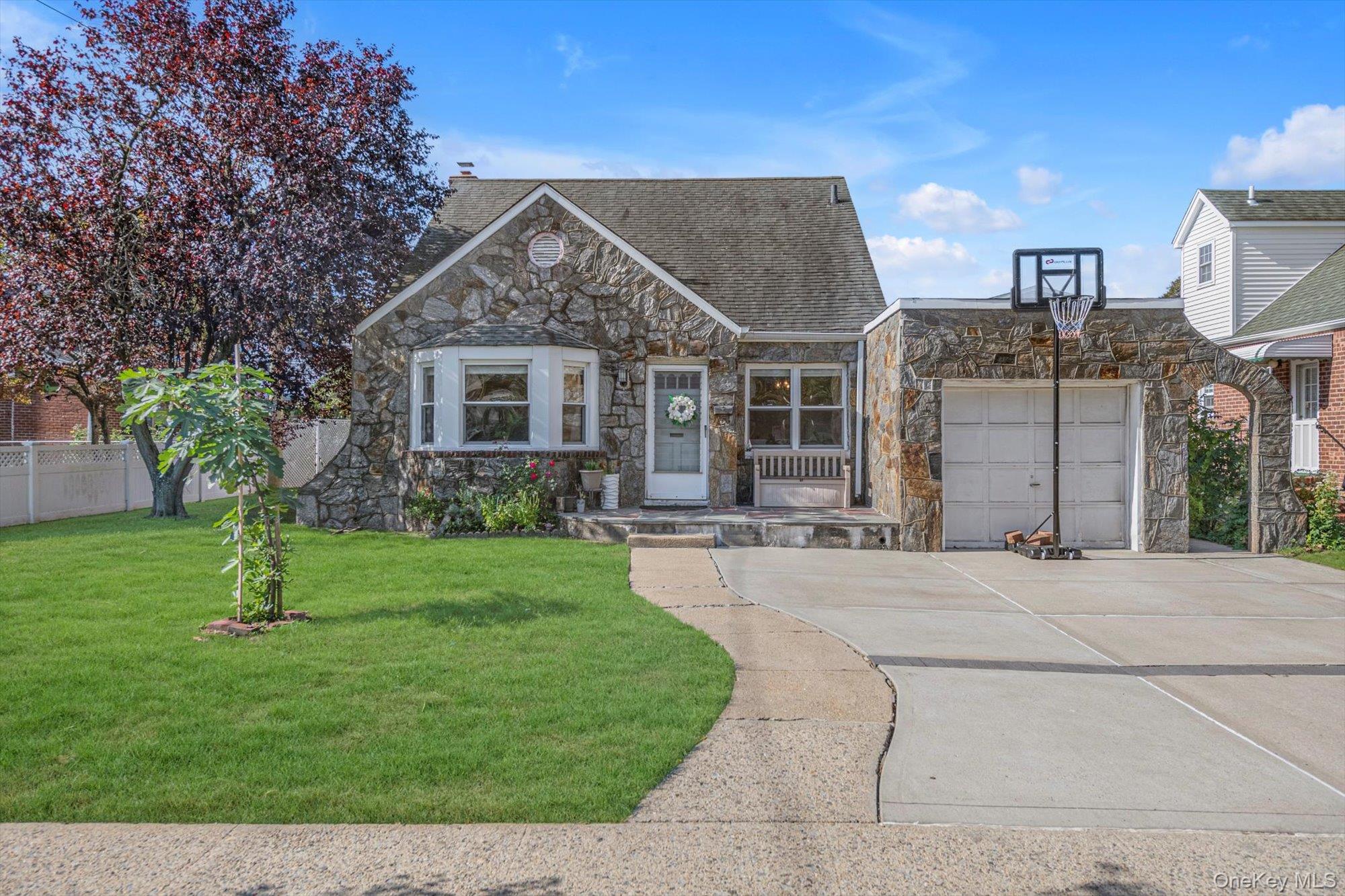 a front view of a house with a yard and trees