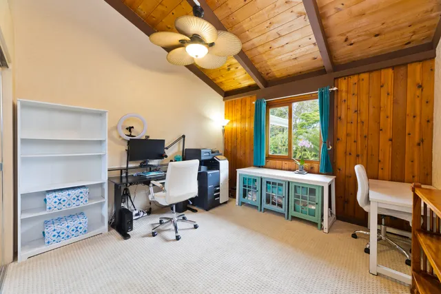 a view of a workspace with furniture and a window
