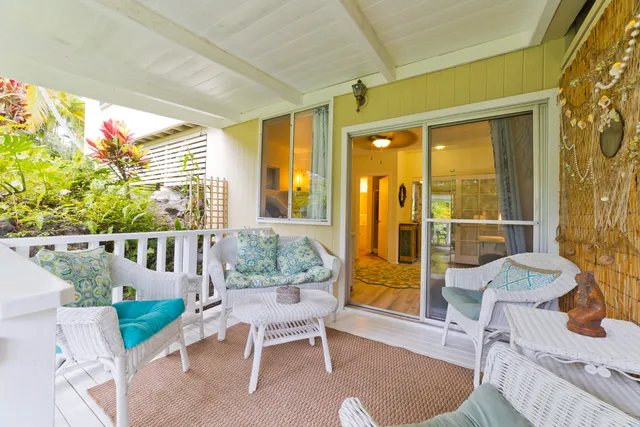a view of a porch with chairs and potted plants