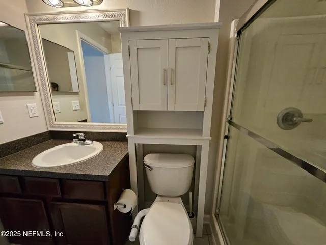 a bathroom with a toilet sink and mirror