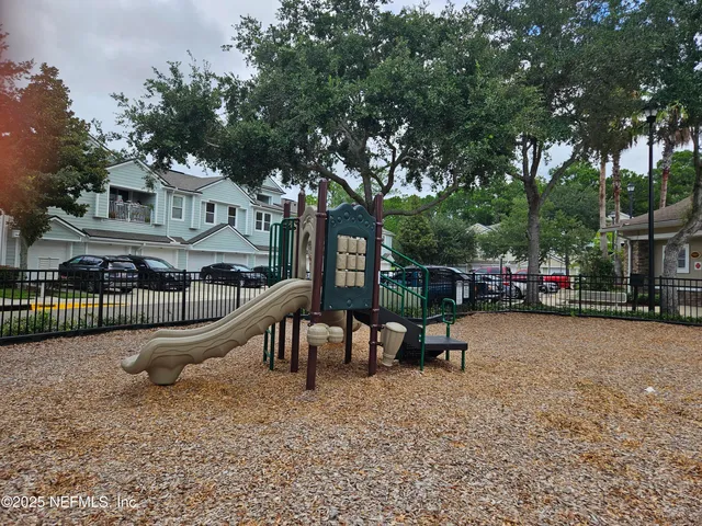 a view of a house with a wooden fence and a bench