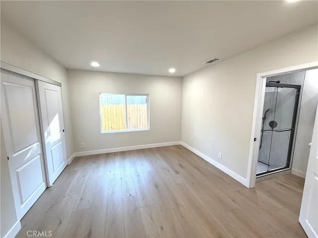 an empty room with wooden floor and a window