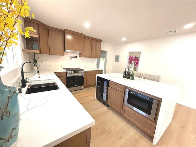 a kitchen with stainless steel appliances kitchen island granite countertop a sink and a stove