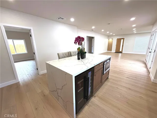 a kitchen with a sink and wooden floor