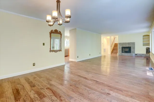 a large kitchen with stainless steel appliances wooden floor and a large window