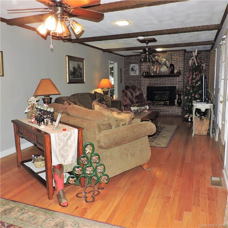 848 South Potter Road Lancaster, SC 29720 - Photo 5 of 24 a living room with furniture a fireplace and a dining table with wooden floor