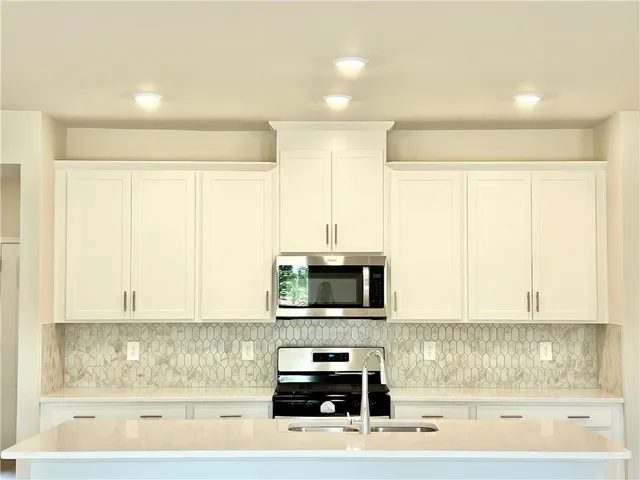 a kitchen with a stove a sink and a microwave