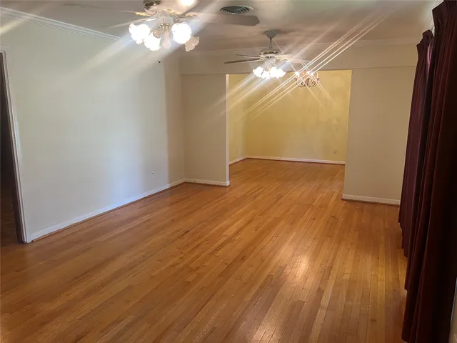 a view of a livingroom with wooden floor and chandelier
