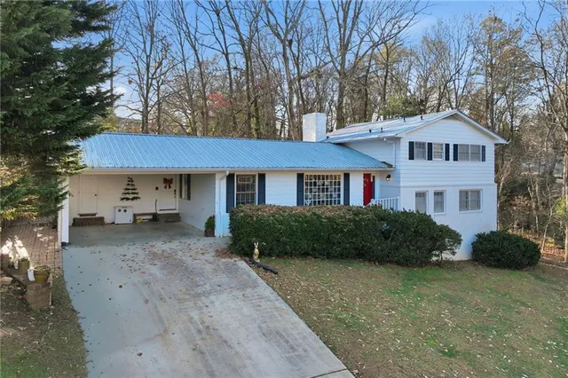 a front view of a house with a yard and trees
