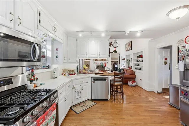 a kitchen with stainless steel appliances kitchen island granite countertop a stove and a refrigerator