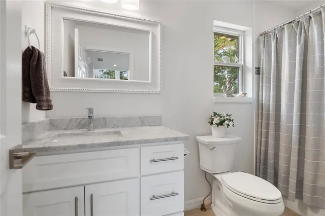a large bedroom with a bed and flat tv screen on the dresser