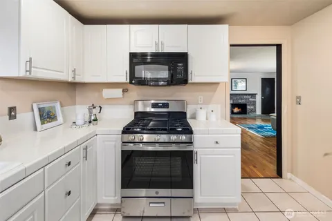 a kitchen with white cabinets and appliances