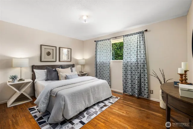 a bedroom with a bed and wooden floor
