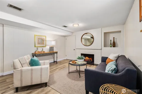 a living room with furniture a fireplace and a window