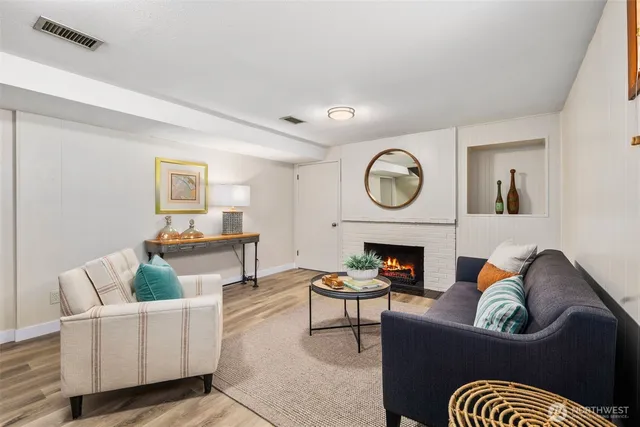 a living room with furniture a fireplace and a window
