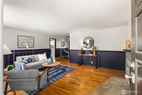 a living room with furniture a rug and wall clock