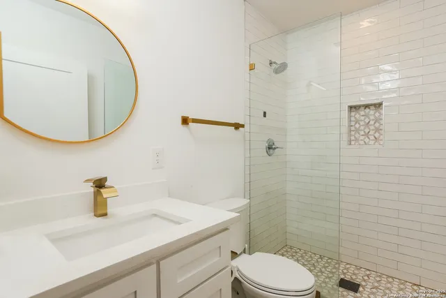 a bathroom with a sink a toilet and shower