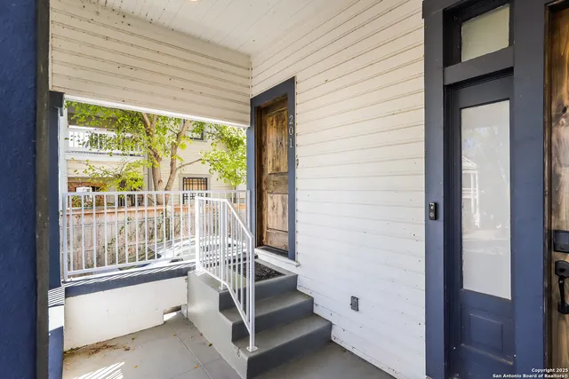 a view of entryway with wooden floor and front door