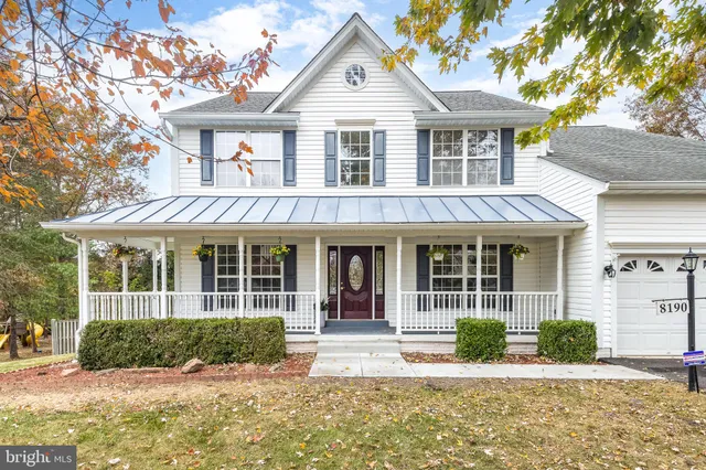 a front view of a house with a yard and potted plants