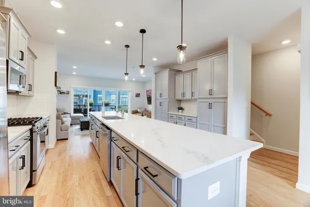 a large kitchen with stainless steel appliances kitchen island granite countertop a large center island and a stove top oven