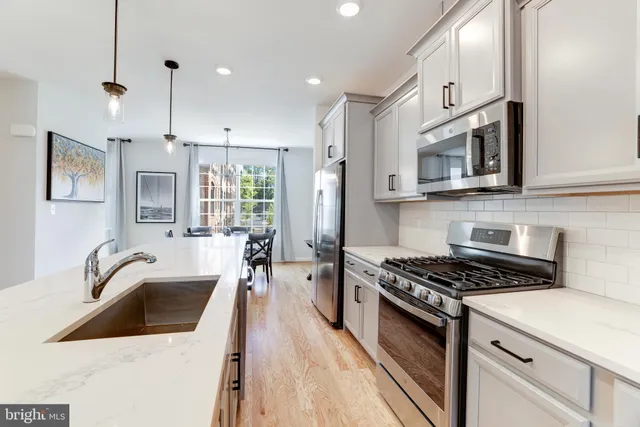 a kitchen with stainless steel appliances a stove sink microwave and cabinets
