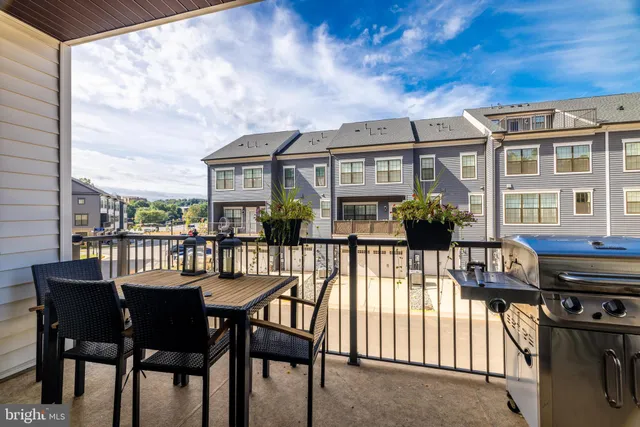 a view of a patio with table and chairs with wooden floor and fence