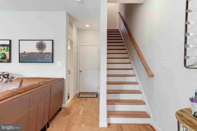 a view of a hallway with stairs and wooden floor