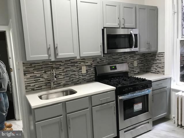 423 South 15th Street Philadelphia, PA 19146 - Photo 6 of 7 a kitchen with granite countertop a stove and a microwave