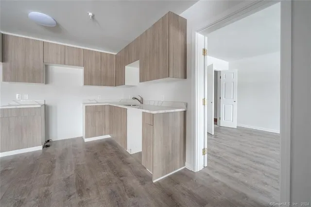 a view of a kitchen with an empty space and a refrigerator