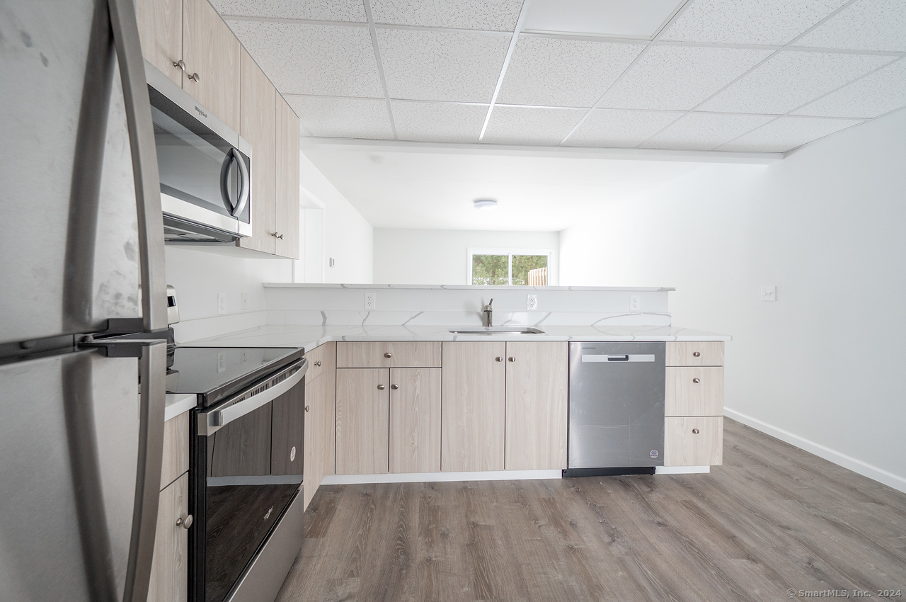 1030 Federal Road, Unit 204 Brookfield, CT 06804 - Photo 14 of 22 a kitchen with a sink cabinets stainless steel appliances and a window