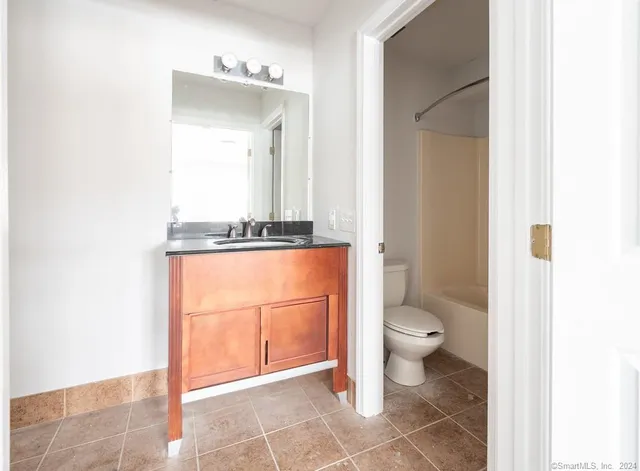 a bathroom with a toilet a sink and mirror