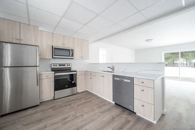 a kitchen with white cabinets and stainless steel appliances