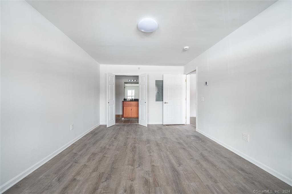 1030 Federal Road, Unit 204 Brookfield, CT 06804 - Photo 7 of 22 a view of an empty room with wooden floor and windows