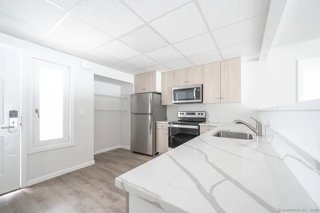 a kitchen with refrigerator a microwave a sink and cabinets