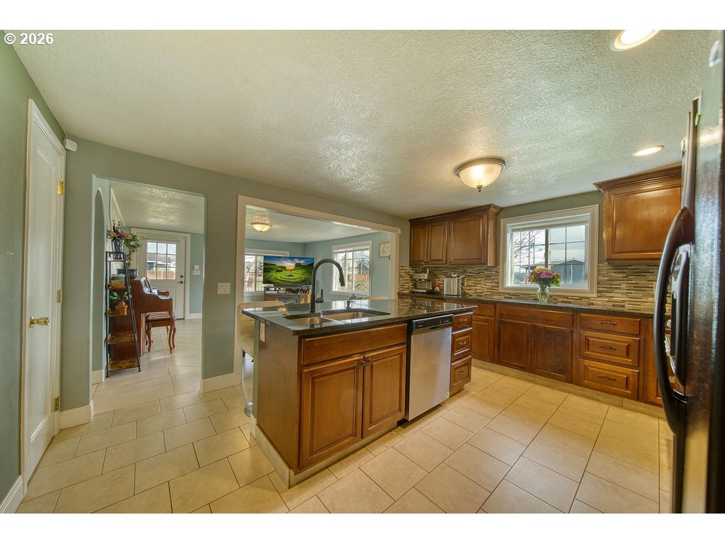 1045 Umatilla Street St. Helens, OR 97051 - Photo 11 of 43 a kitchen with stainless steel appliances granite countertop a refrigerator and a sink