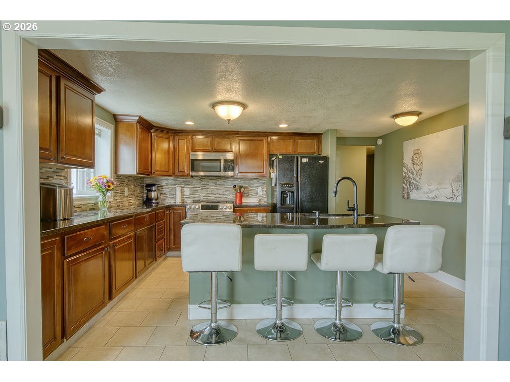 1045 Umatilla Street St. Helens, OR 97051 - Photo 13 of 43 a kitchen with a table chairs refrigerator and cabinets