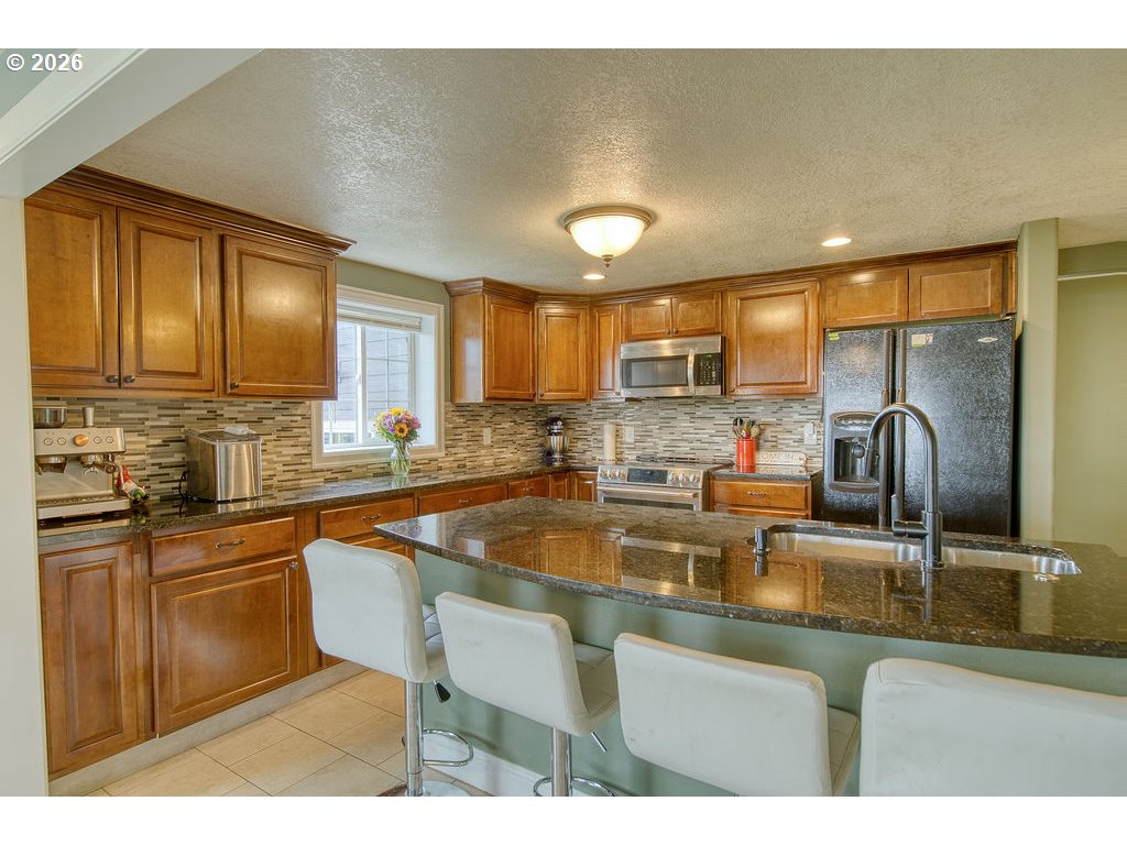 1045 Umatilla Street St. Helens, OR 97051 - Photo 15 of 43 a kitchen with stainless steel appliances granite countertop a sink a stove and cabinets