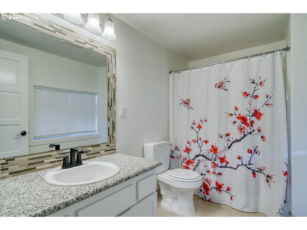 1045 Umatilla Street St. Helens, OR 97051 - Photo 18 of 43 a bathroom with a granite countertop sink a mirror and a toilet