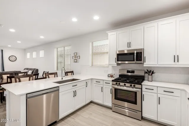 a kitchen with white cabinets stainless steel appliances and sink
