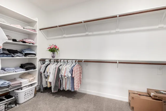 a view of walk in closet with clothes and shoes