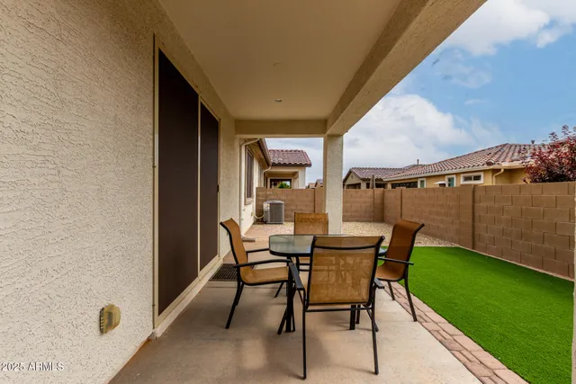 a view of a patio with table and chairs and garden