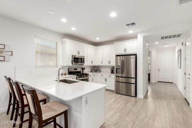 a kitchen with refrigerator a microwave a stove a table and chairs