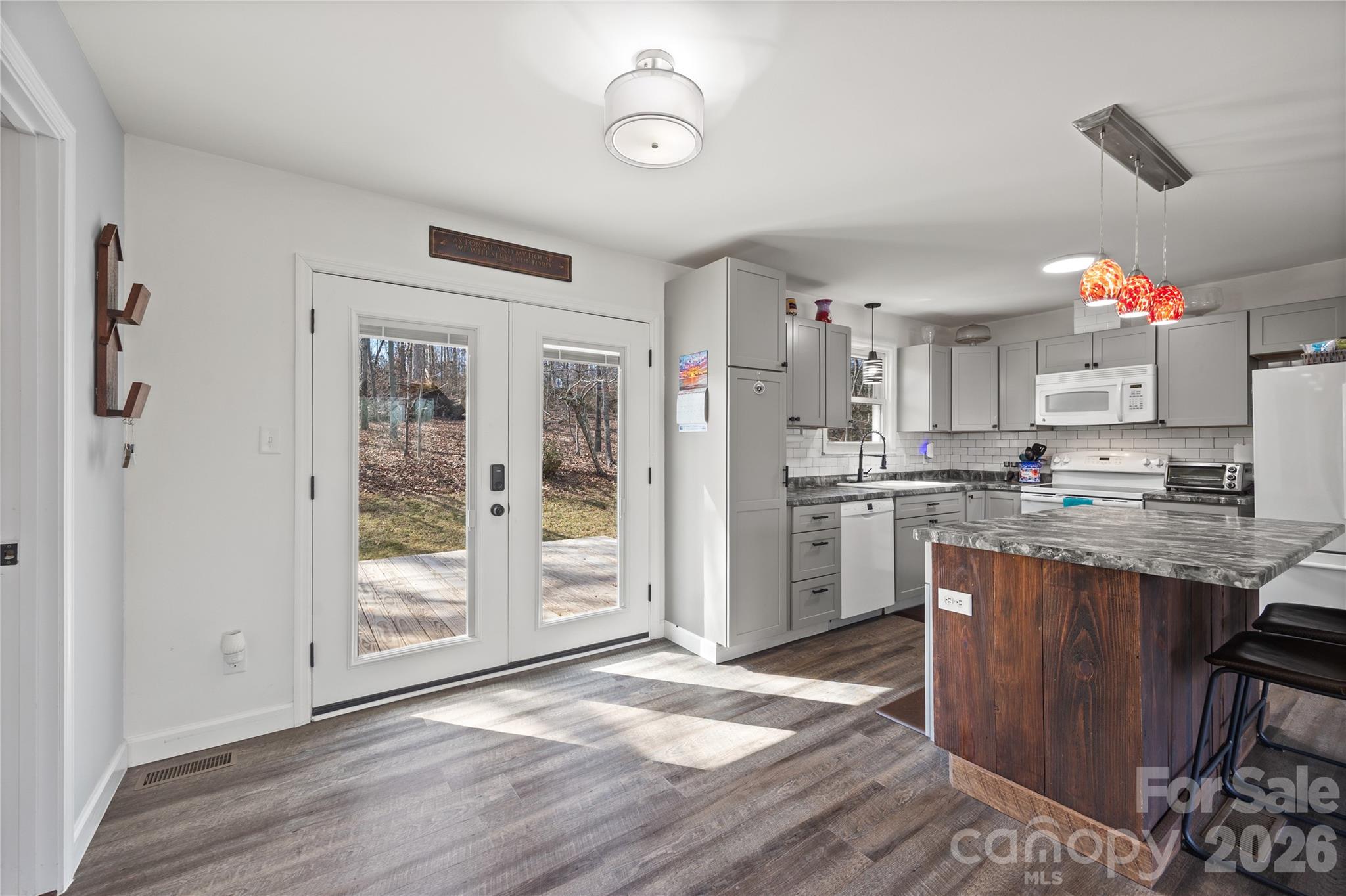 7137 Reeps Grove Church Road Vale, NC 28168 - Photo 11 of 33 a kitchen with stainless steel appliances granite countertop a refrigerator oven a sink dishwasher and white cabinets with wooden floor