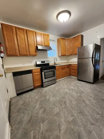 a kitchen with stainless steel appliances granite countertop a refrigerator a stove a sink and a microwave