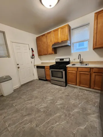 a kitchen with stainless steel appliances granite countertop a sink stove and cabinets