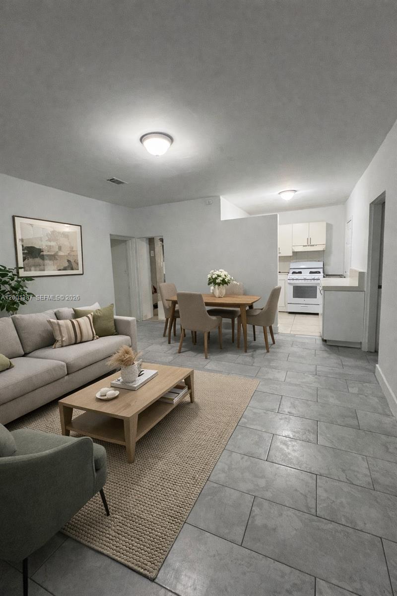 413 Northwest 33rd Street, Unit A Miami, FL 33127 - Photo 2 of 8 a living room with furniture and a table