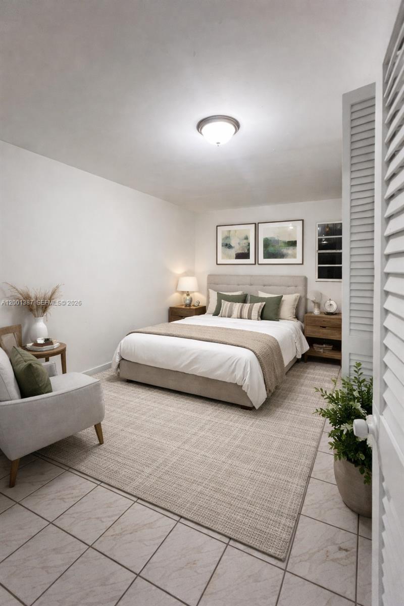 413 Northwest 33rd Street, Unit A Miami, FL 33127 - Photo 3 of 8 a bedroom with a bed and a couch