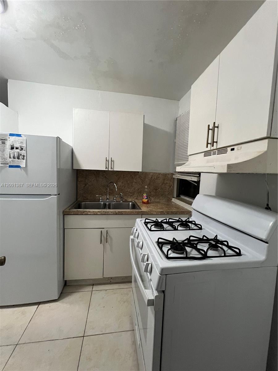 413 Northwest 33rd Street, Unit A Miami, FL 33127 - Photo 5 of 8 a kitchen with stainless steel appliances granite countertop a stove a refrigerator and a sink